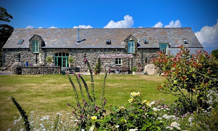 View from the garden across the large lawn towards Ysgubor Degwm barnconversion self catering holiday let in North Wales